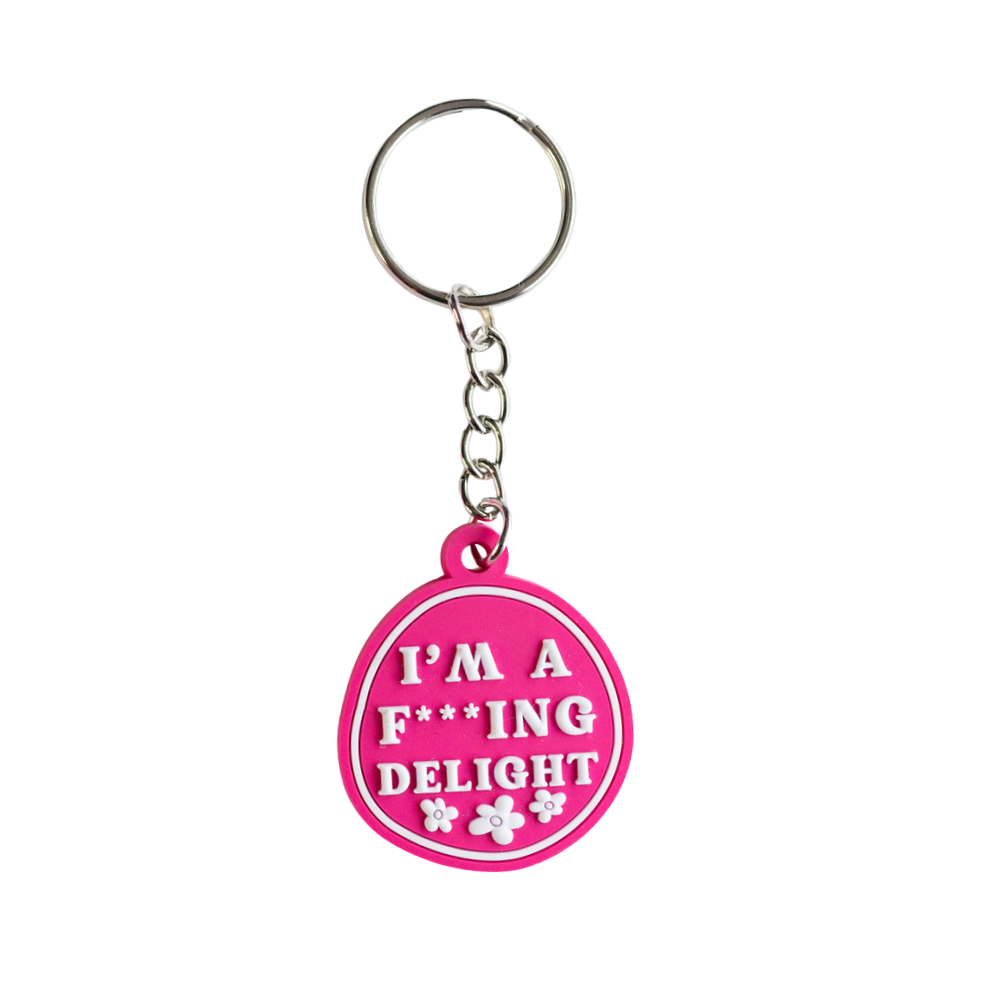 Hilarious keychain gift: pink irregular circle with raised white letters: I'm a F***ing delight. Full view