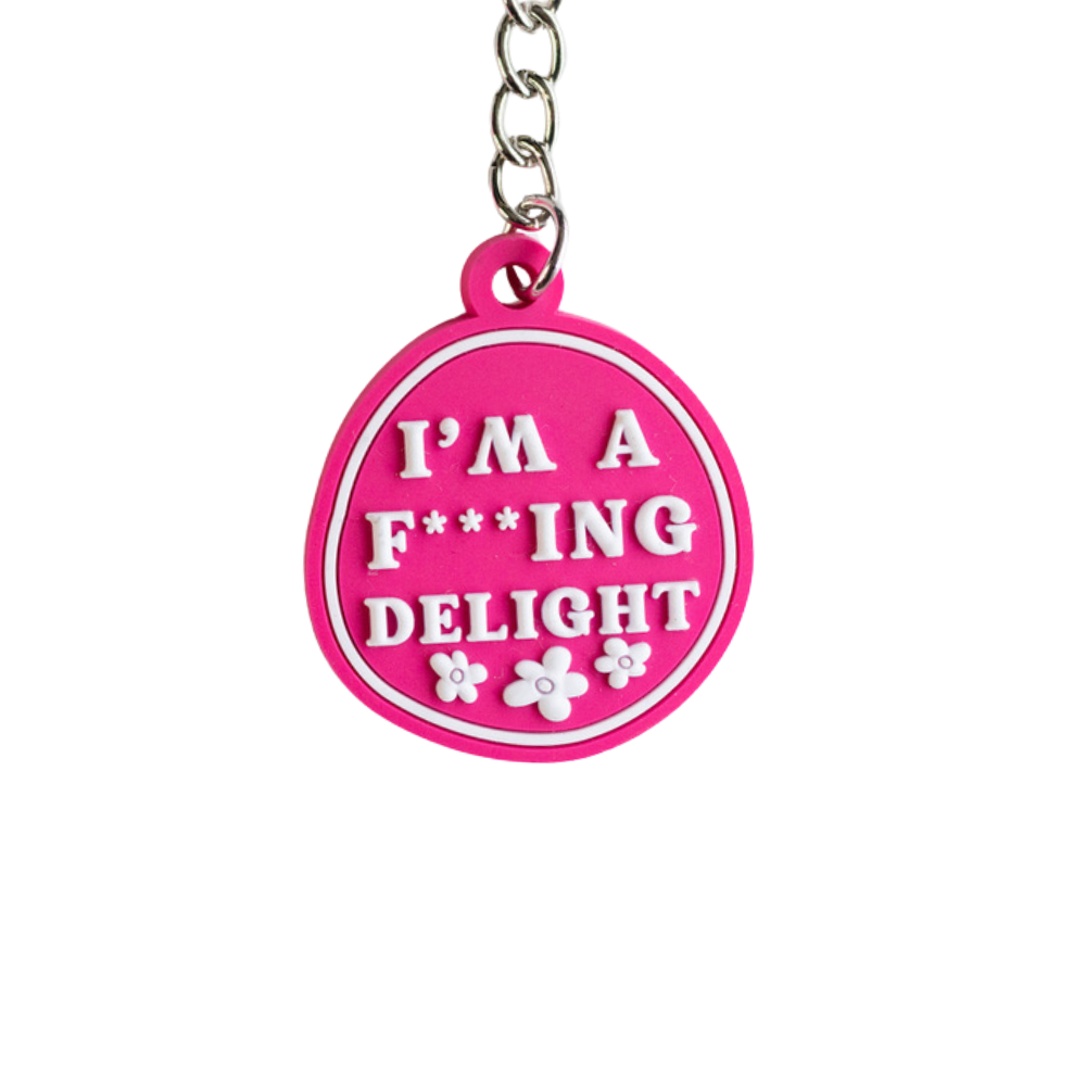 Hilarious keychain gift: pink irregular circle with raised white letters: I'm a F***ing delight. Close up