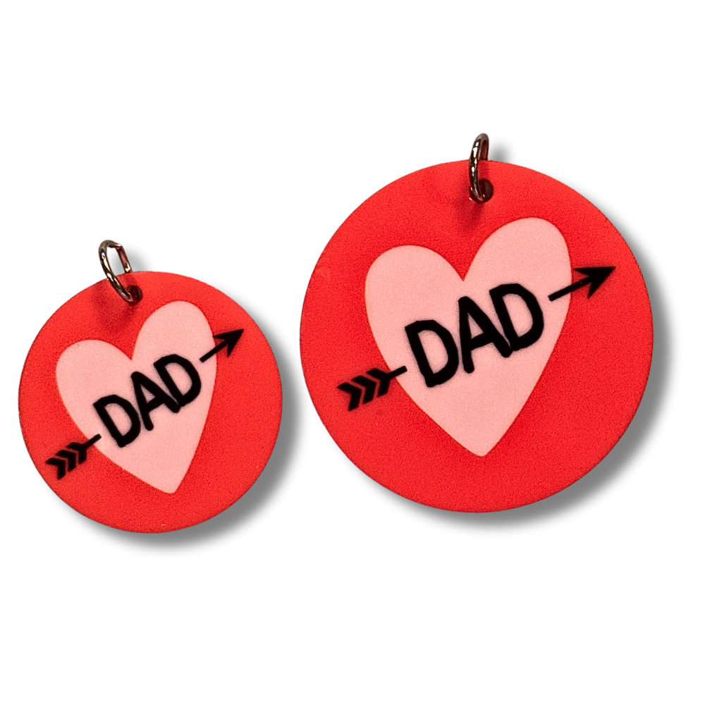 two sizes of pet collar charm for Valentine's day dog... round dark pink/red circle with lavender heart and black text "DAD" with arrow through it.