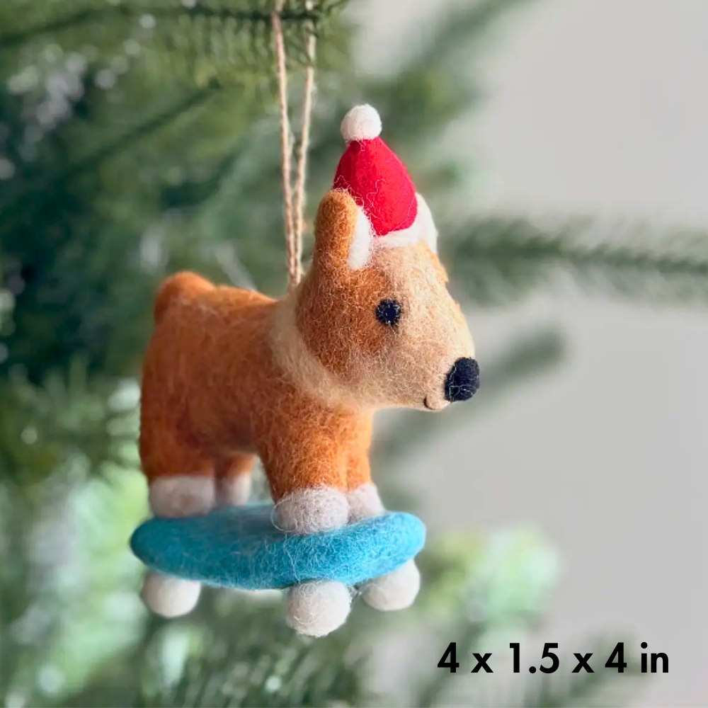 Felt Corgi dog ornament / party decor hanging on a Christmas tree surrounded by pine needles