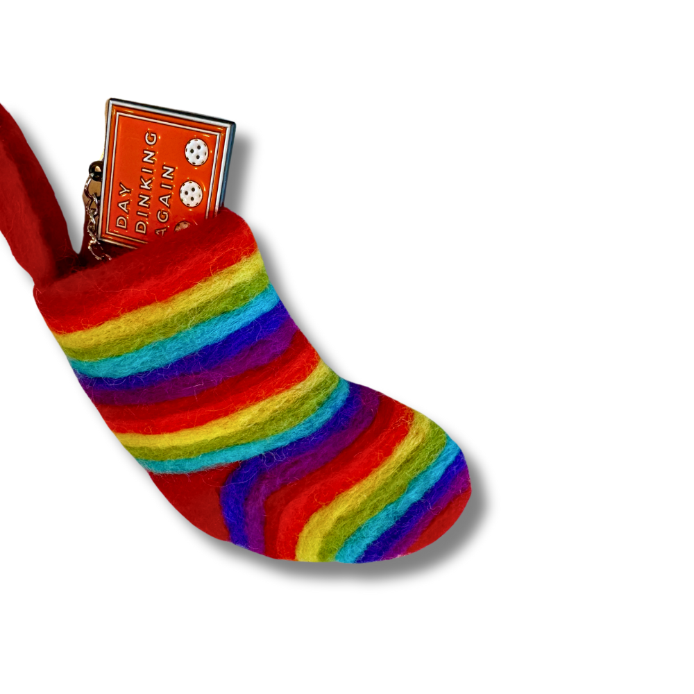 mini rainbow Pride holiday Christmas stocking filled with a keychain (sticking out to show size comparison)