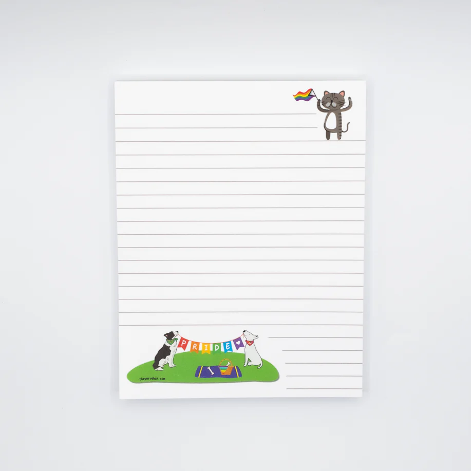 lined notepad. Pride themed. Cat in upper right corner waving Pride flag. Dogs on bottom of page are sitting on grass having a picnic. They are holding a string banner that spells PRIDE.