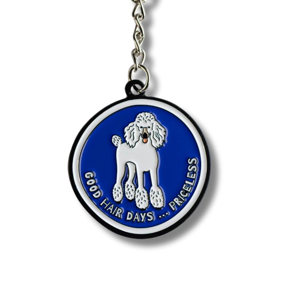 Blue round enamel poodle keychain with white poodle and white and black border. Text: good hair days ... priceless. close up view of keychain.