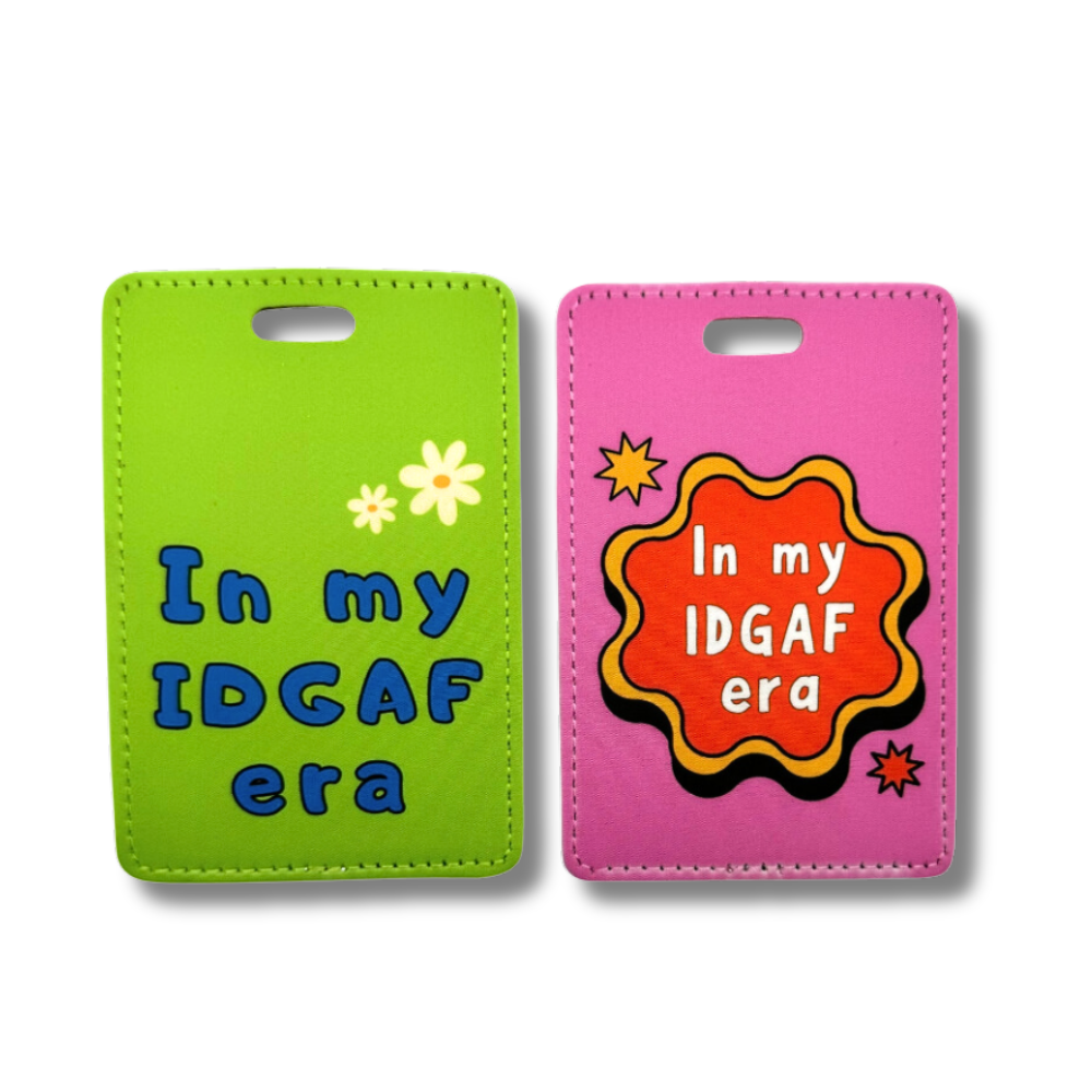 funny travel luggage tags "In my IDGAF era" in two colors; green with blue letters and two white daisies and hot pink with yellow and red retro circle shape and white letters.