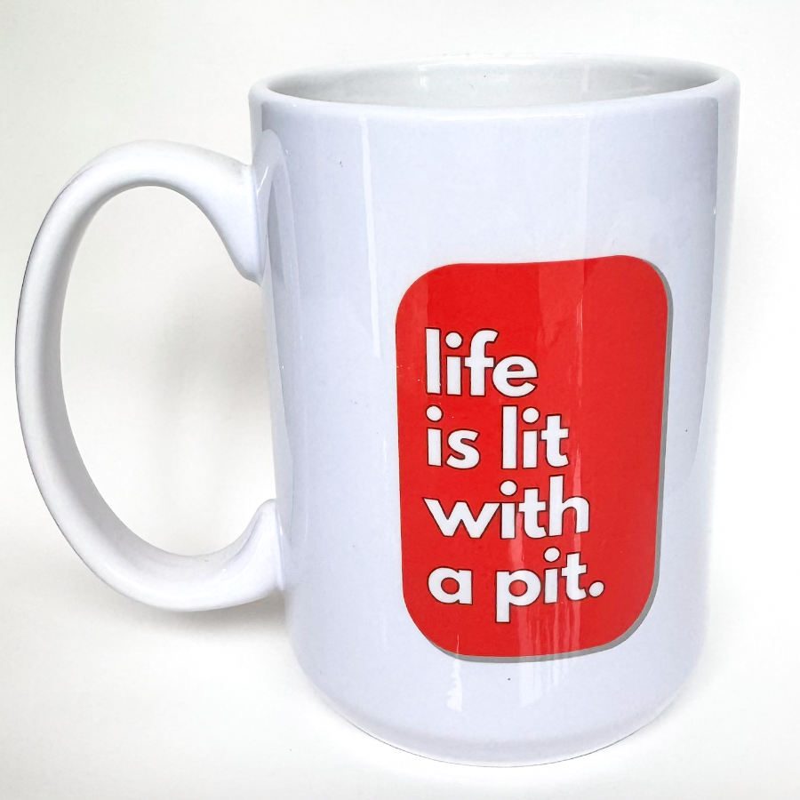 A white ceramic coffee mug with a red design that says 'LIFE IS LIT WITH A PIT' and features a small graphic of a pit bull dog.