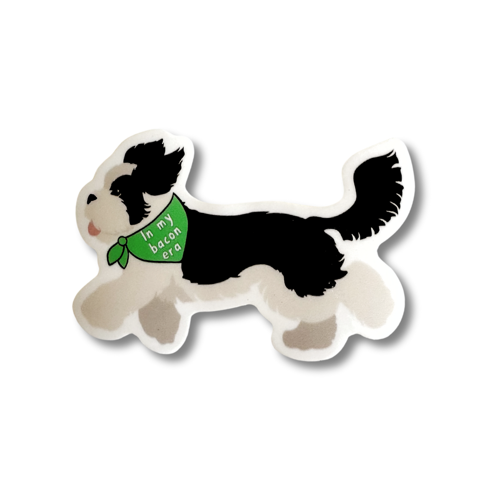 Cute sheepadoodle sticker. Black and white dog is running and wearing a green bandana that says" In my bacon era.