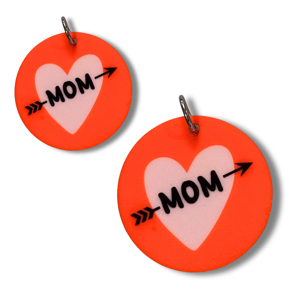 Two sizes of dog mom collar charms. Red circles with lavender heart and "mom" with an arrow through it.