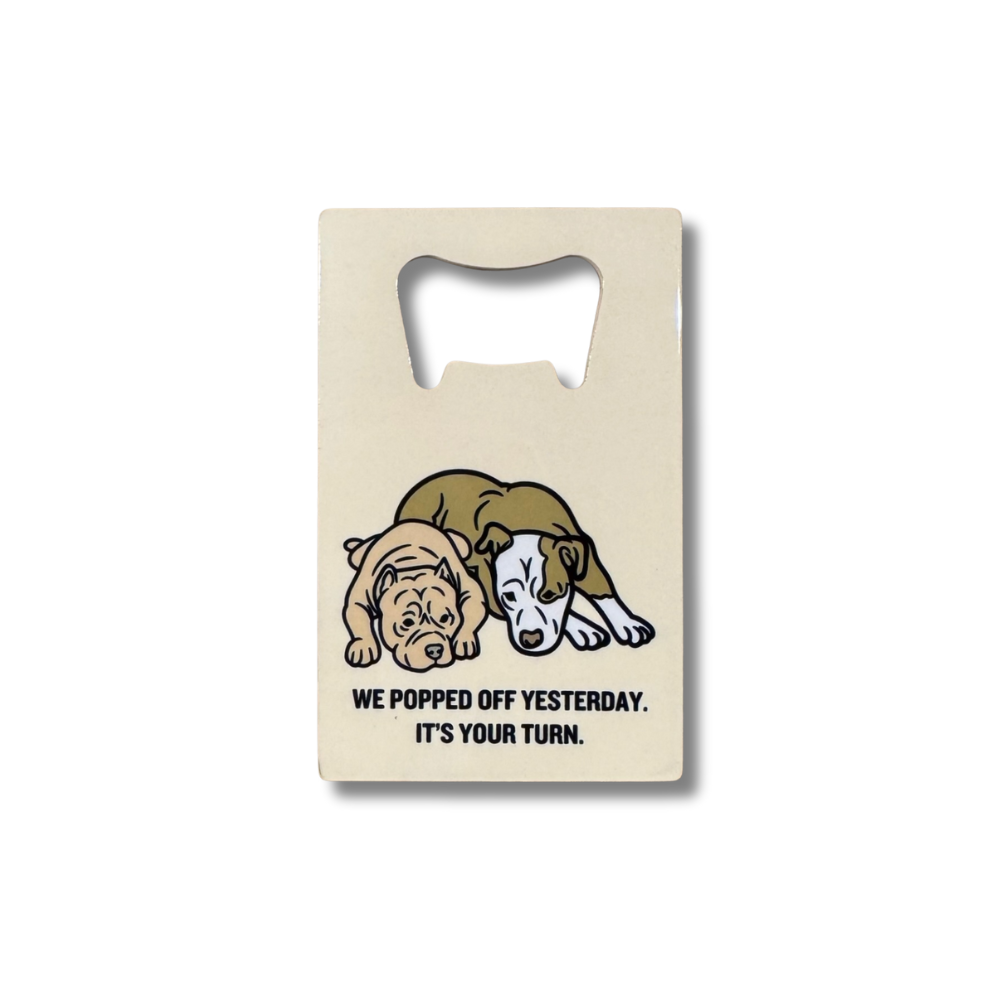 Beige dog bottle opener with two resting pit bull-style dogs and text “We popped off yesterday. It’s your turn”