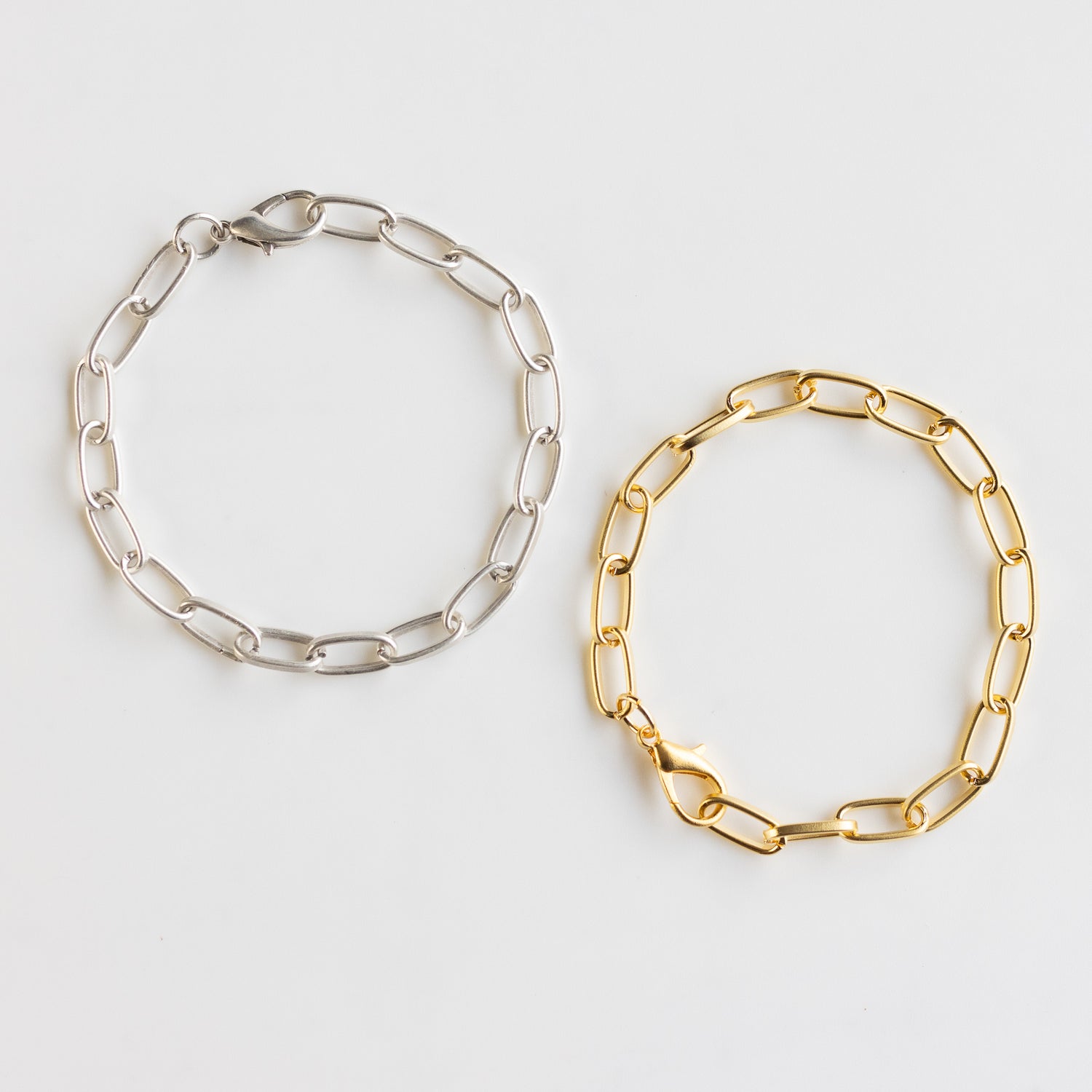 Gold plated chain link bracelet on the right and silver plated chain link bracelet on the left. Great as charm bracelets or alone.