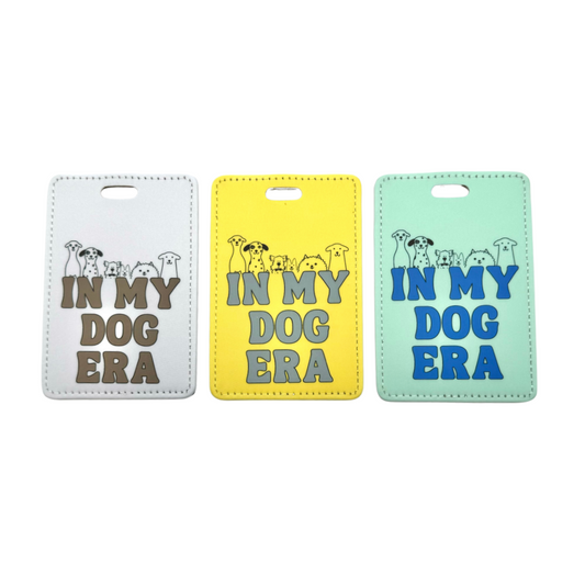 In my Dog Era funny ID tag for luggage for dog moms and dads who travel. From left: gray, yellow, and green color options. Line art of dogs above the words.