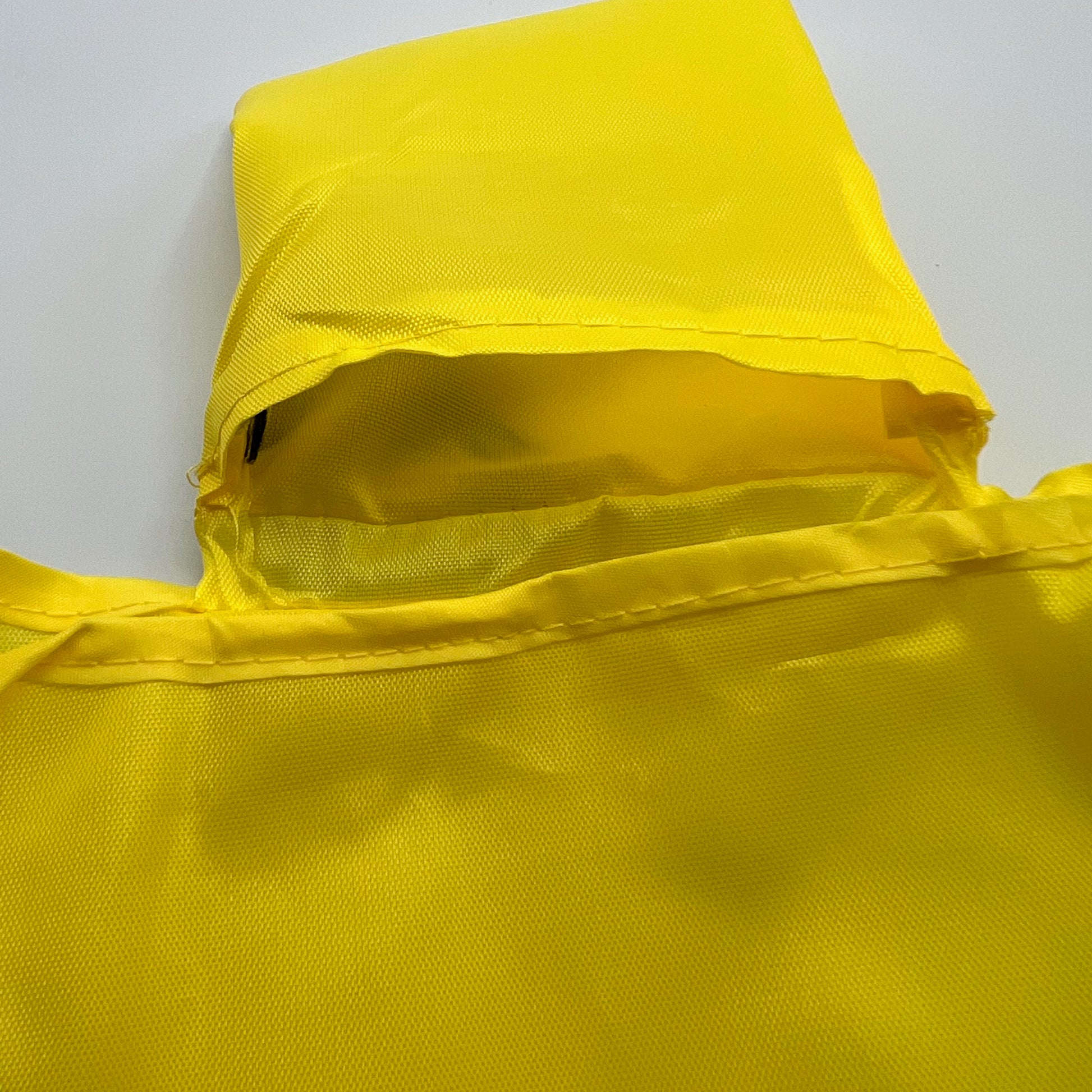 close up of pouch on inside of the yellow grocery bag , approximately 4" x 4"