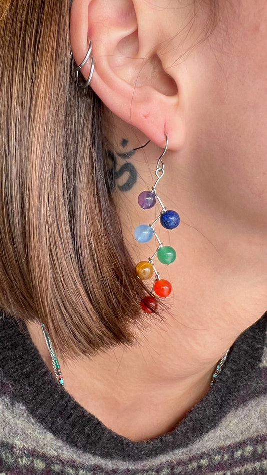 colorful dangle earrings on model, view of ear and neck