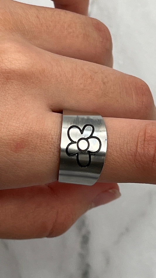 Contemporary wide stainless steel ring with a black minimalist cartoon flower line drawing