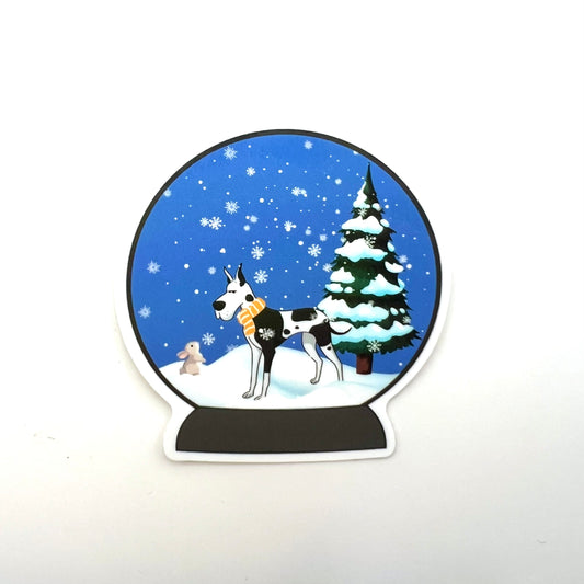 Snow globe sticker with a winter scene. Great dane looking at a bunny in the snow.