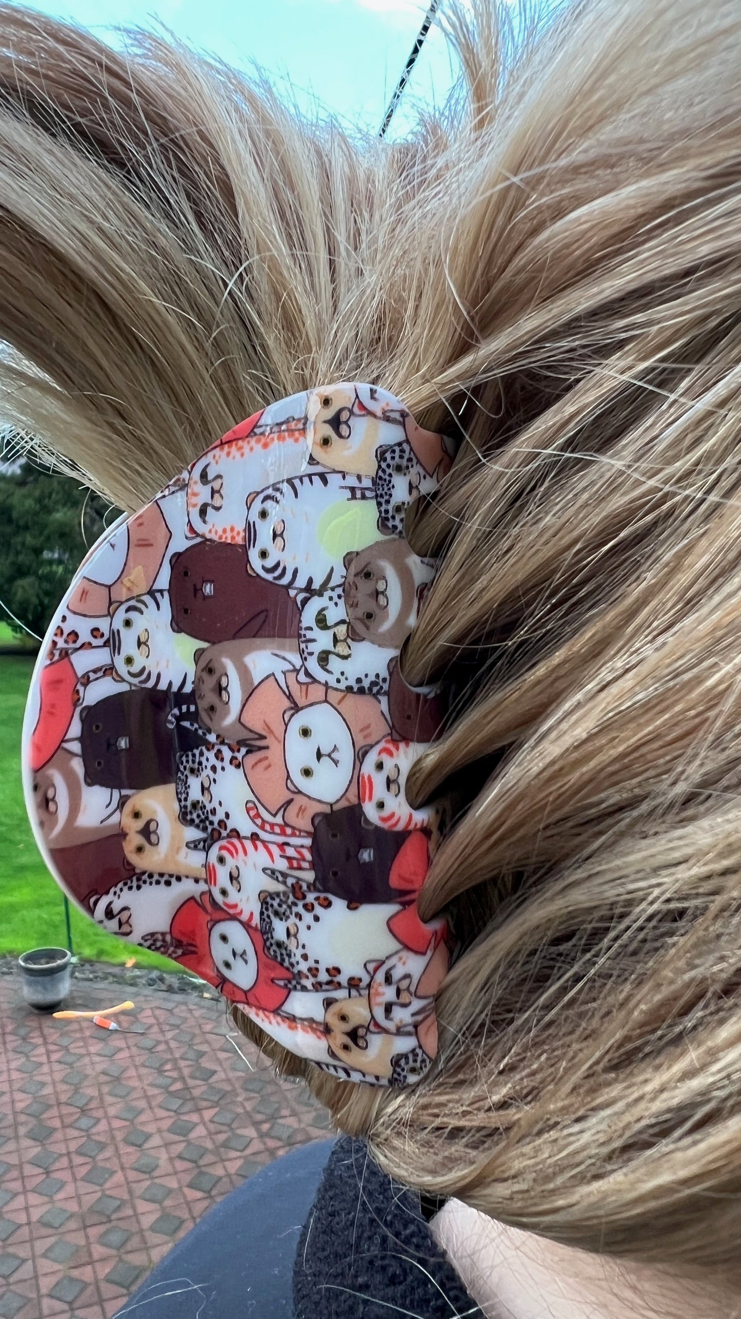 Medium/Large claw style hairclip. Collage of cartoon brown, orange, white, and black cats on it.