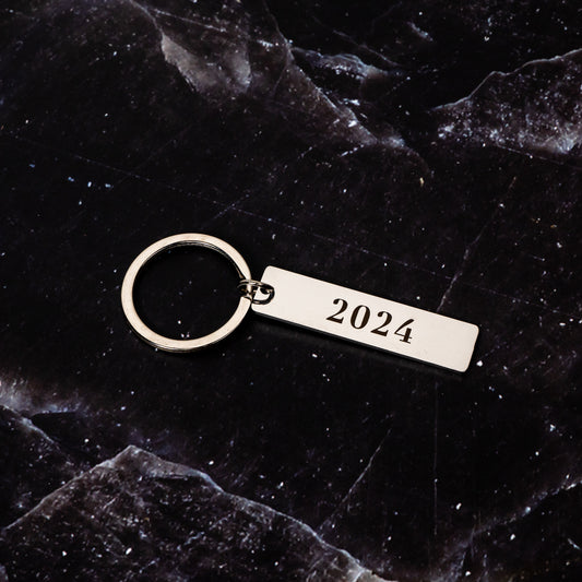minimalist silver keychain, narrow rectangle with 2024 numbers punched through to create blank space