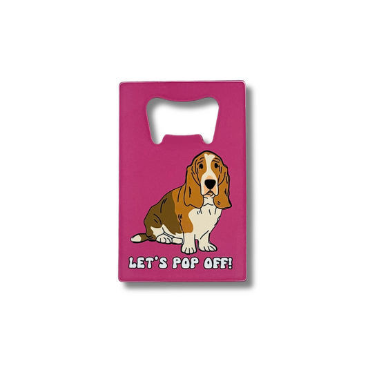 Dark pink flat bottle opener that fits in wallet featuring a brown and white basset hound and words: Let's pop off!