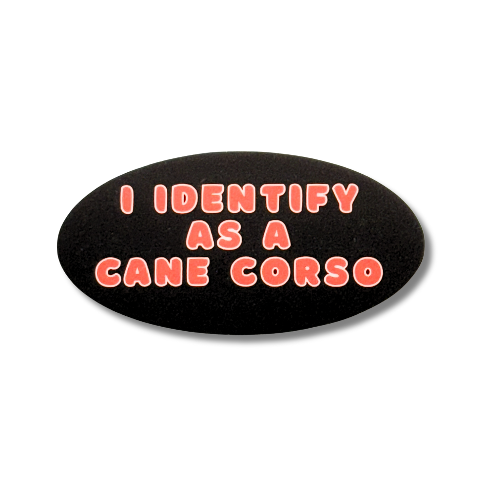 humorous sticker for person with big personality "I identify as a cane corso." Black oval with red text.