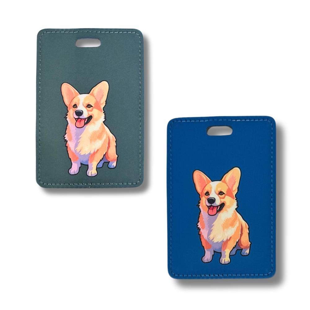 image of two corgi  luggage tags, both with the same corgi art of tan and white corgi dog. Suitcase tag on left has a dark gray background. Tag on right has a dark blue background.