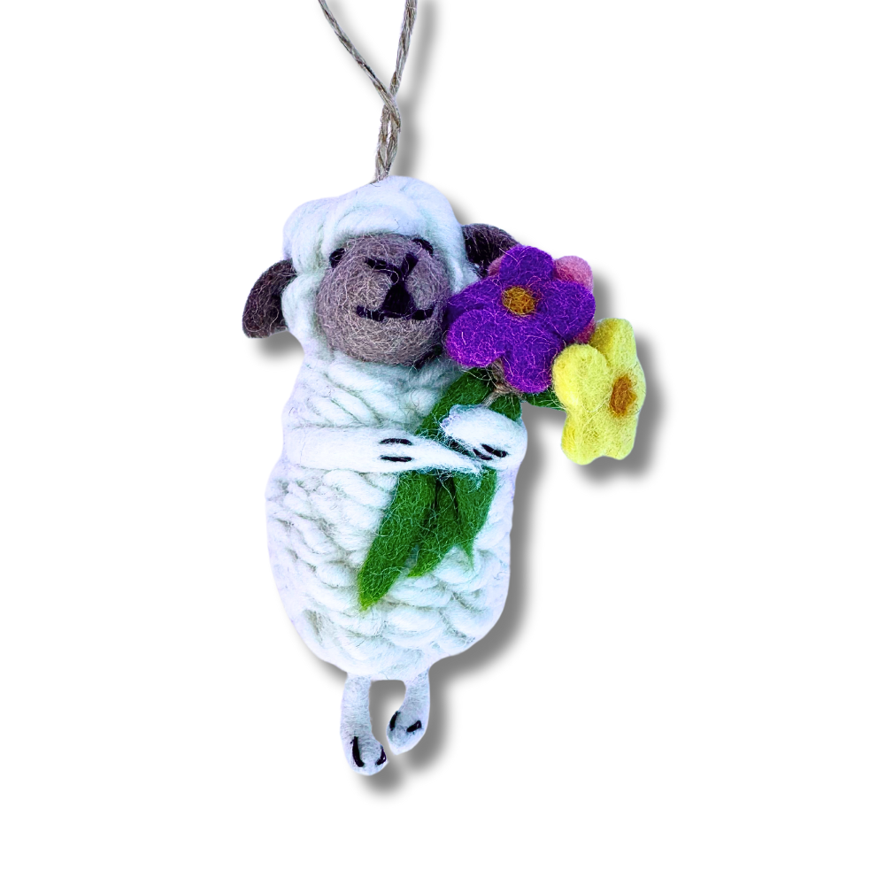 felt sheep ornament - white sheep clutching a large bouquet of purple, yellow, and pink flowers. View - ornament is hanging.