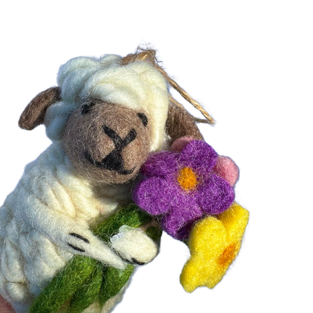 felt sheep ornament - white sheep clutching a large bouquet of purple, yellow, and pink flowers. view - close up of upper part of the lamb and the bouquet