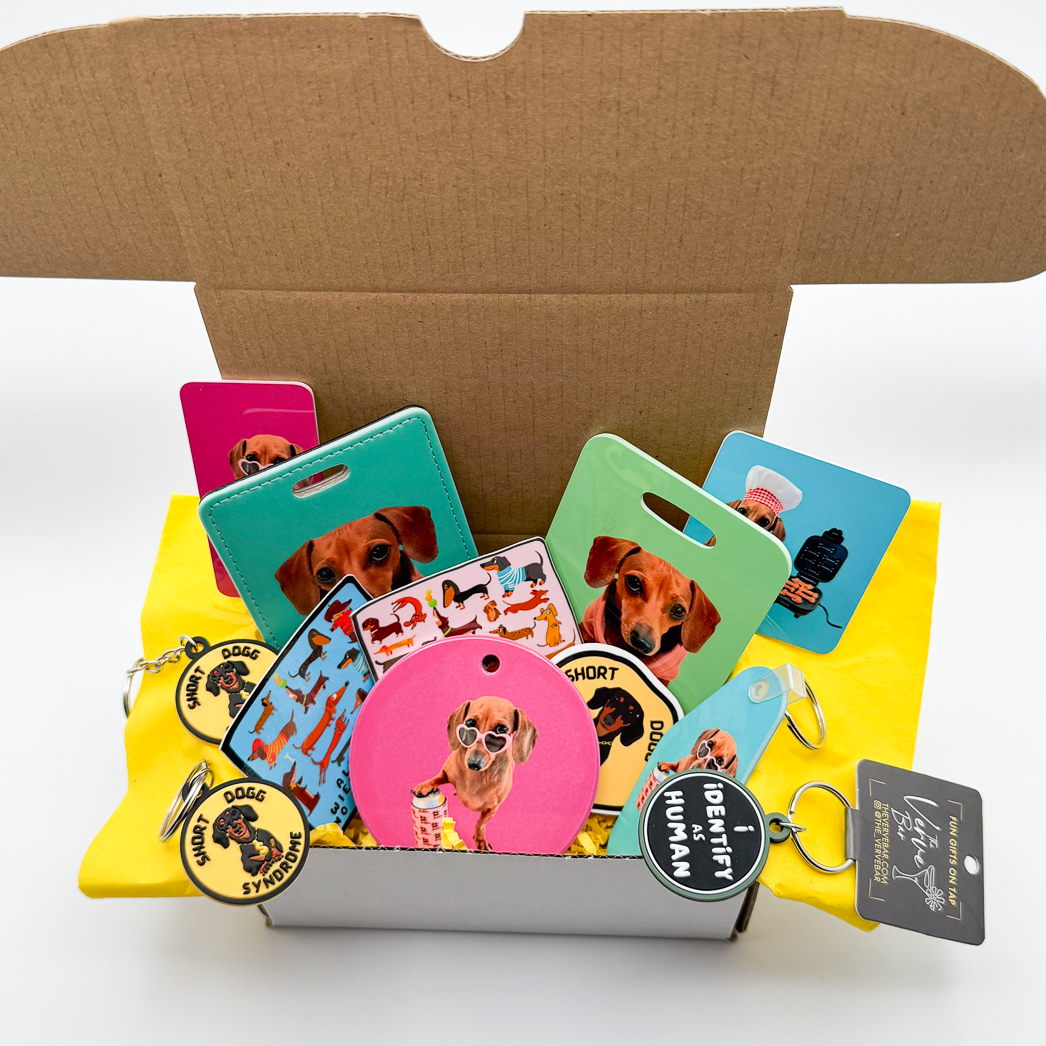 dachshund gift basket includes custom ornament (sample in this picture is pink), dachshund stickers, custom magnets, custom bag tags, and funny dog tags.