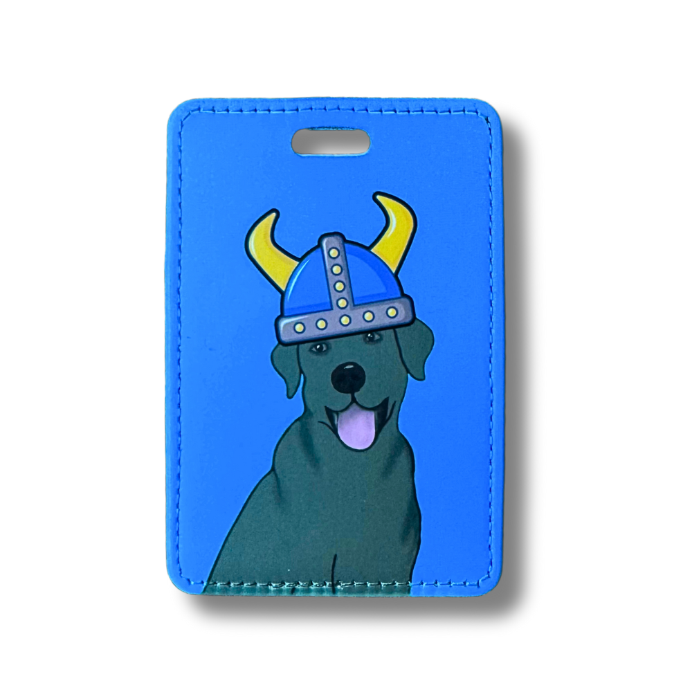 Chocolate lab or black lab dog luggage tag. The labrador is wearing a viking hat. Blue background.