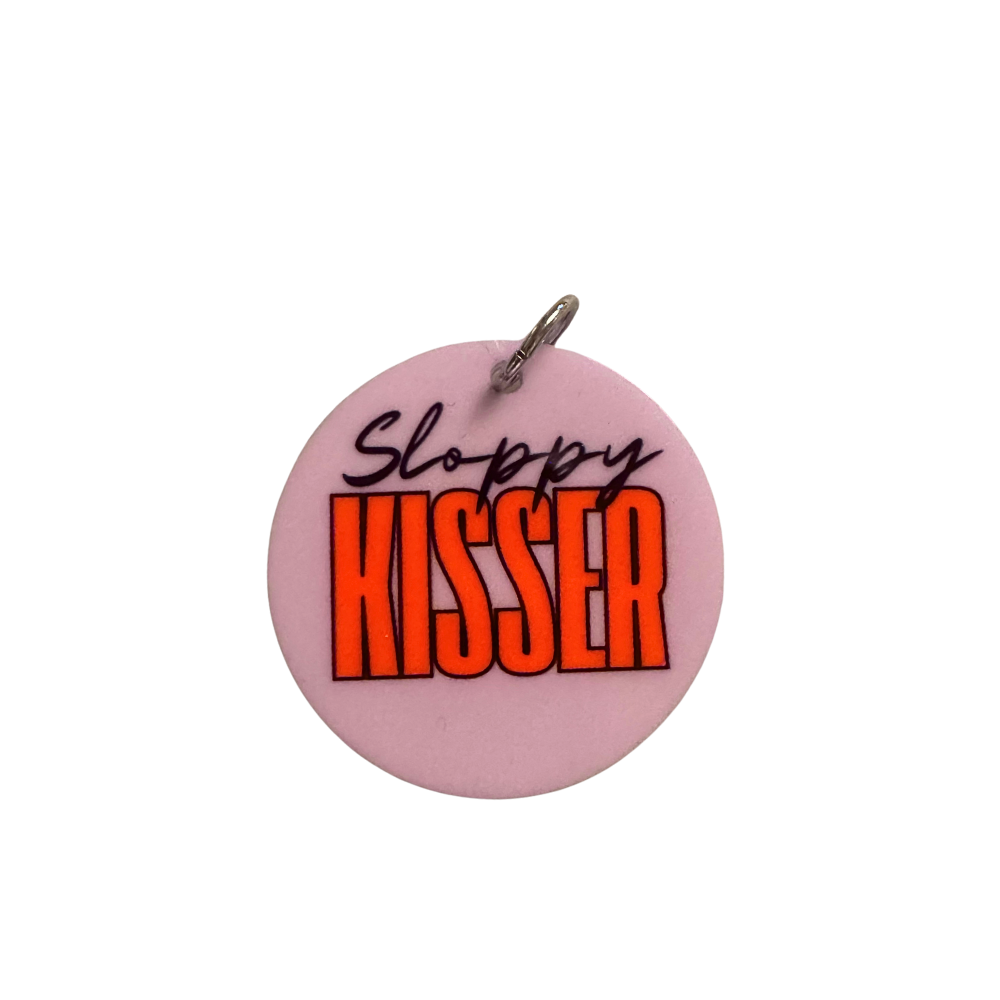 Cute dog accessory for valentines. Lavender circle with black script font "Sloppy" and tall modern font "Kisser." shown standard size for most dog breeds