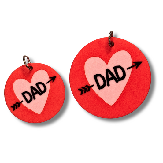 two sizes of pet collar charm for Valentine's  day dog... round dark pink/red circle with lavender heart and black text "DAD" with arrow through it.