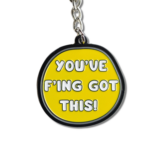 yellow round-ish enamel keychain with gray and black border and white text: You've f'ing got this!