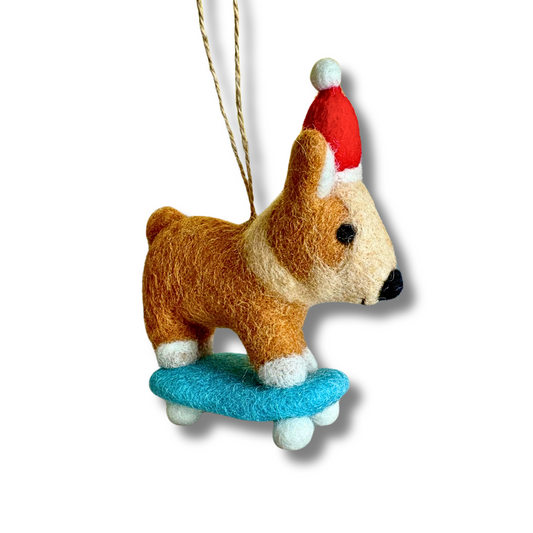 Felt Corgi dog ornament / party decor; pup is wearing a Santa hat riding a blue skateboard.