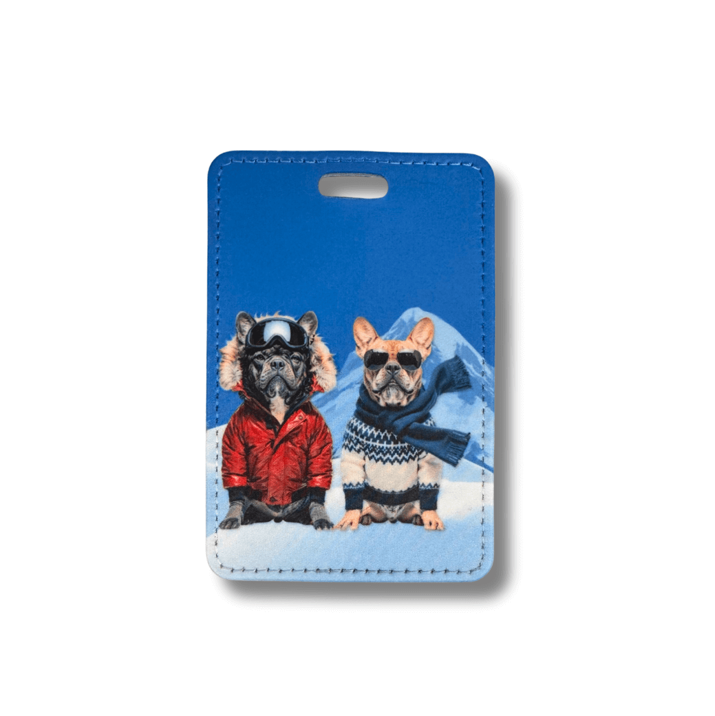 Luggage tag featuring two French Bulldogs in winter ski attire and a mountain / blue background