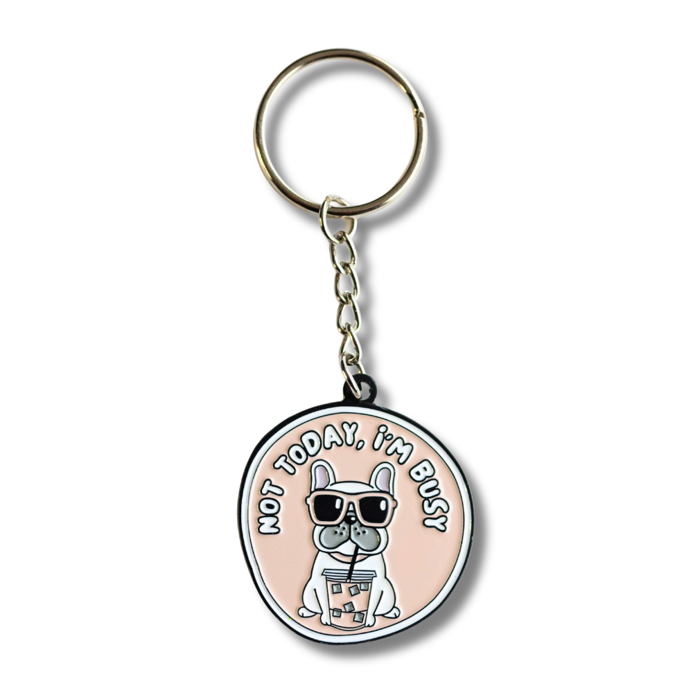 French bulldog enamel keychain. Pale pink with white font. White Frenchie drinking bubble tea and looking sassy: not today, I'm busy