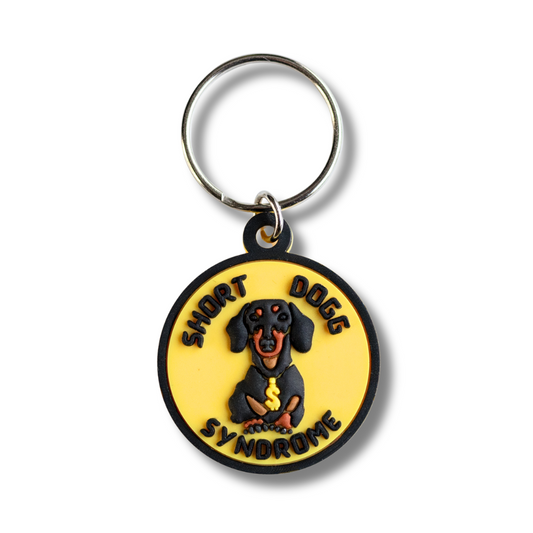 yellow round collar charm for dogs; image of dachshund wearing a gold rapper chain. Words "short dogg syndrome"