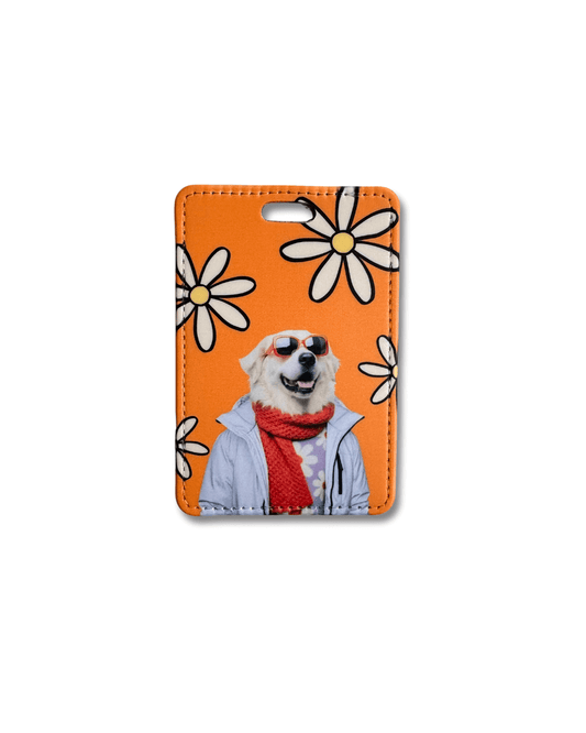 funny great pyrenees luggage tag; white great pyrenees wearing glasses, gray jacket, and dark orange scarf on an orange background with white flowers