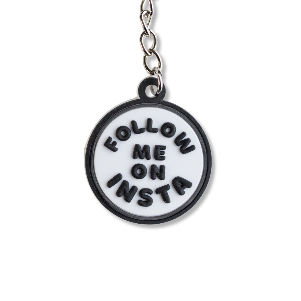 close up of white circle keychain for influencer:  black border and black words: follow me on insta. All black parts are raised 3-D