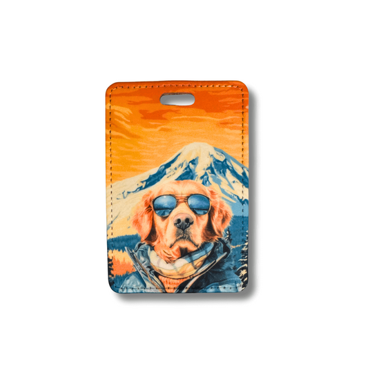 Golden Retriever in ski goggles and parka in front of mountain scene printed on faux leather luggage tag with plastic loop attachment.