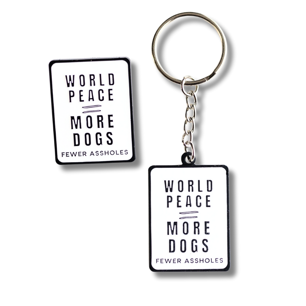 white rectangle enamel keychain and pin combo: world peace = more dogs / fewer assholes