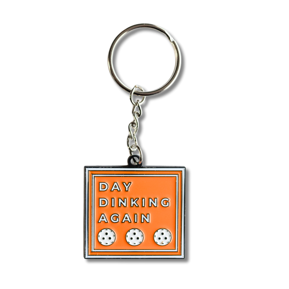 Overall view: Orange square enamel Pickleball keychain. White text with 3 white Pickleballs: Day Dinking Again