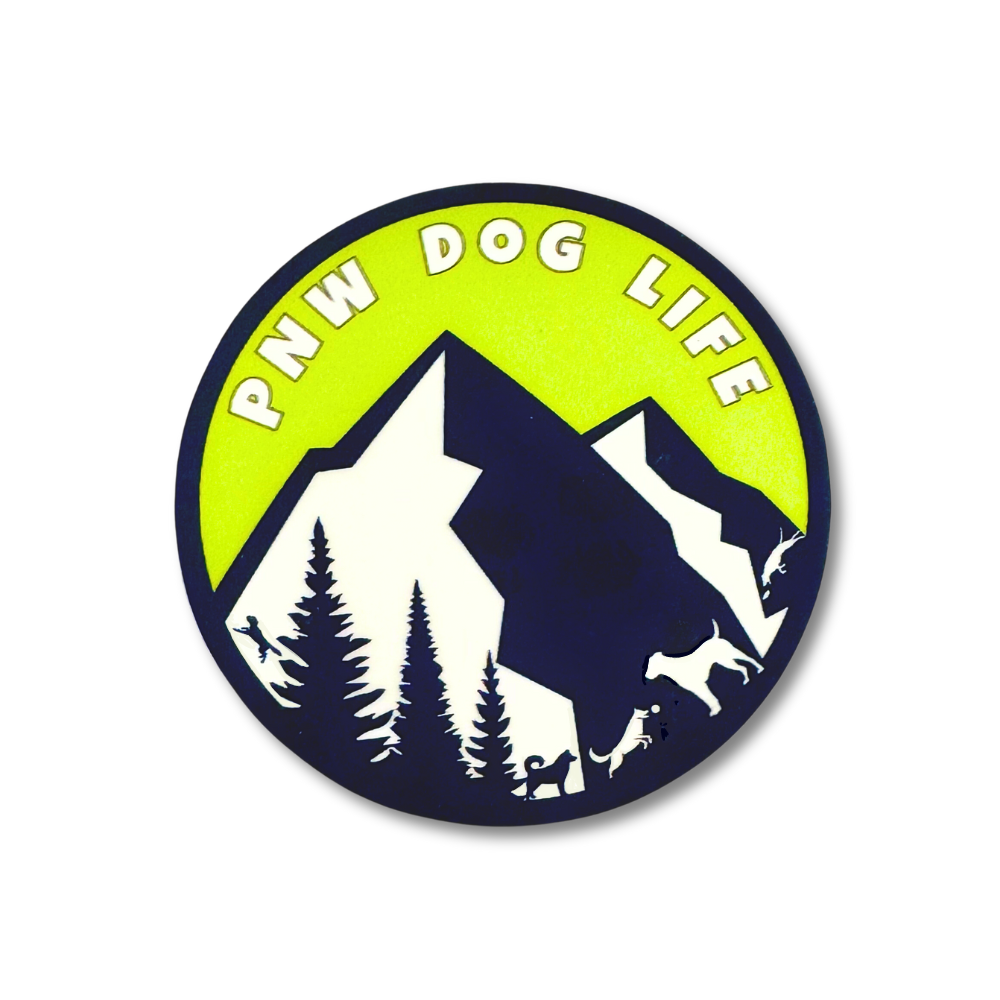 green, navy, and white circle sticker with mountain, trees, and dog silhouettes of dogs playing