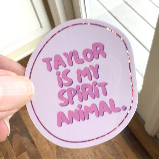 video showing sparkle of irregular circle shaped pale pink sticker with thin glitter outline "Taylor is my spirit animal"
