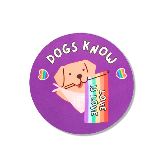 2.25" round pride pin. Purple with rainbow hearts. A dog holding a rainbow "love is love" flag.