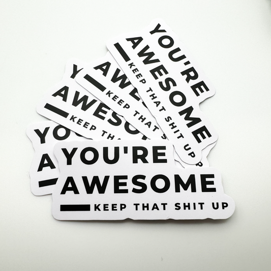 minimalist black and white sticker "you're awesome ... keep that shit up"  (shown here in bulk - a pile of the same sticker)