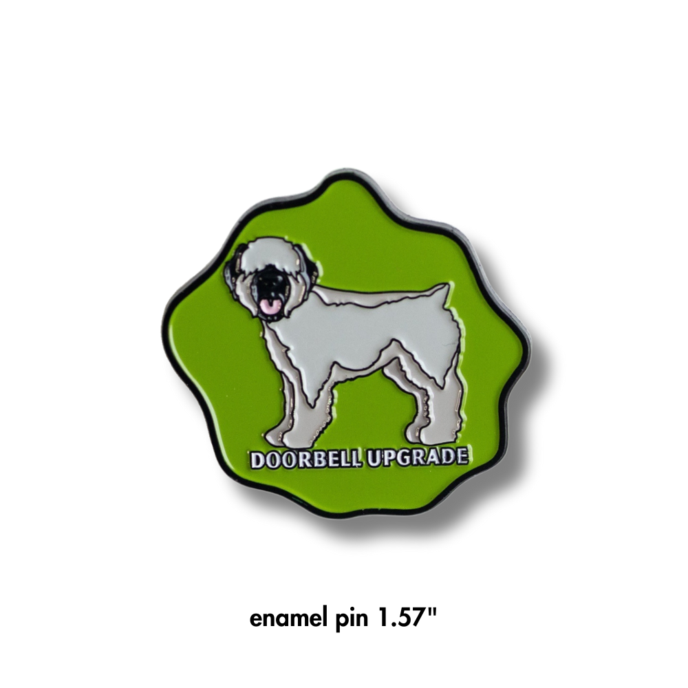 Wheaten terrier dog pin. Enamel approximately 1.6". Green with black border and wheaten terrier dog in center. Caption: doorbell upgrade.