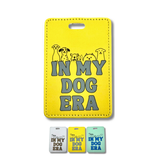 Yellow suitcase tag for dog lover "In my dog era" with 6 line art dogs poking out over the words.