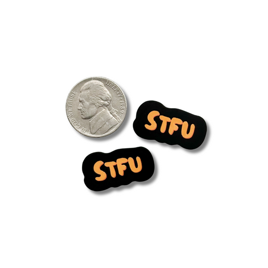 tiny stickers: black and orange "STFU" shown next to a nickel for size comparison