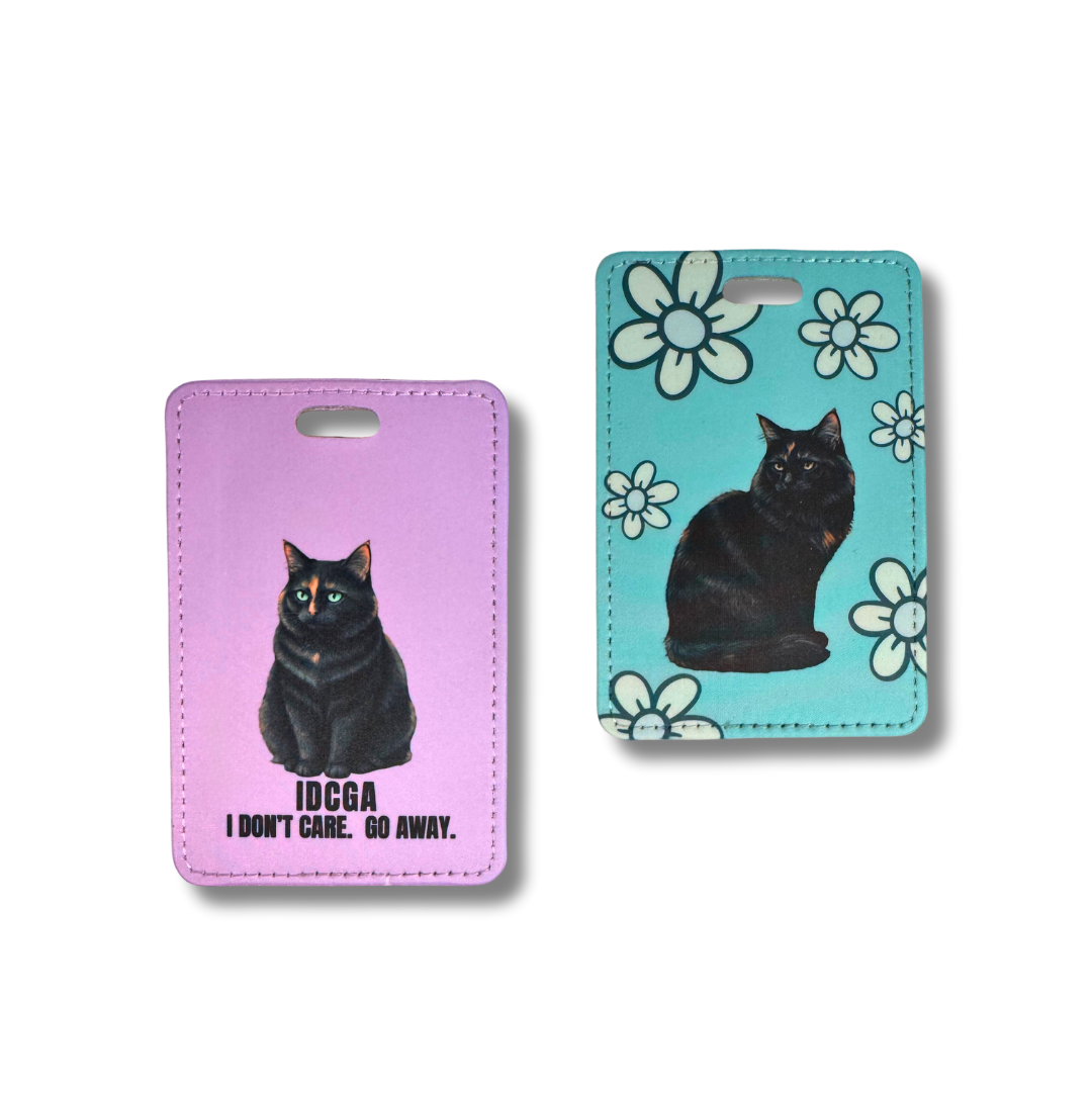 two styles of tortie cat luggage tags, left one is lavender background with text and turquoise with white flowers.