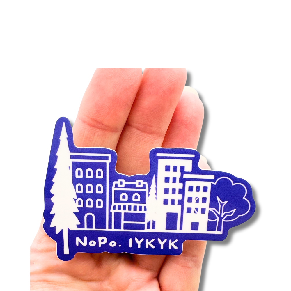 Size comparison against a hand to show size of this North Portland sticker of the cute Shopping Distric.